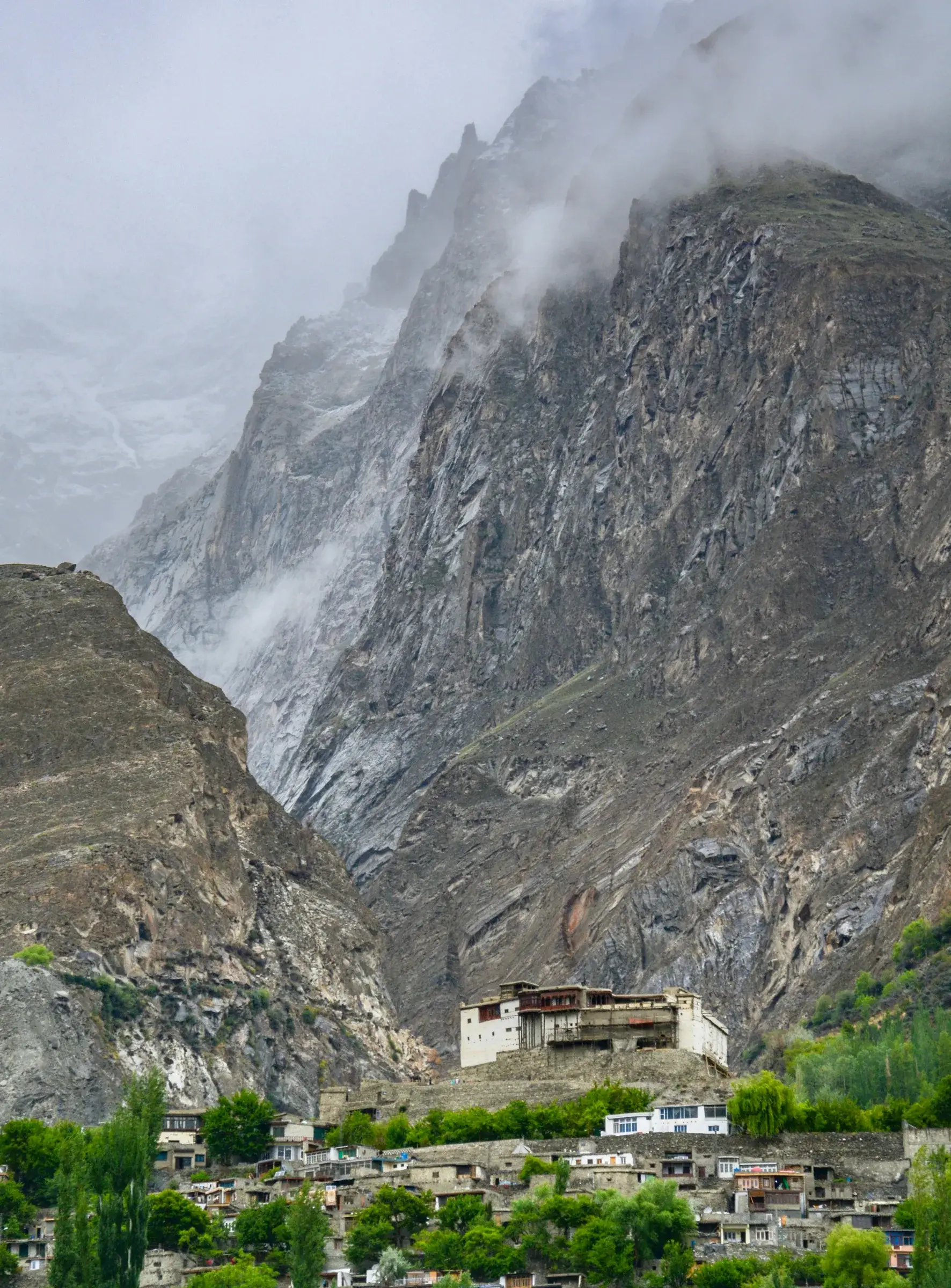 Baltit Fort above the buildings of Karimabad beneath steep mountains.