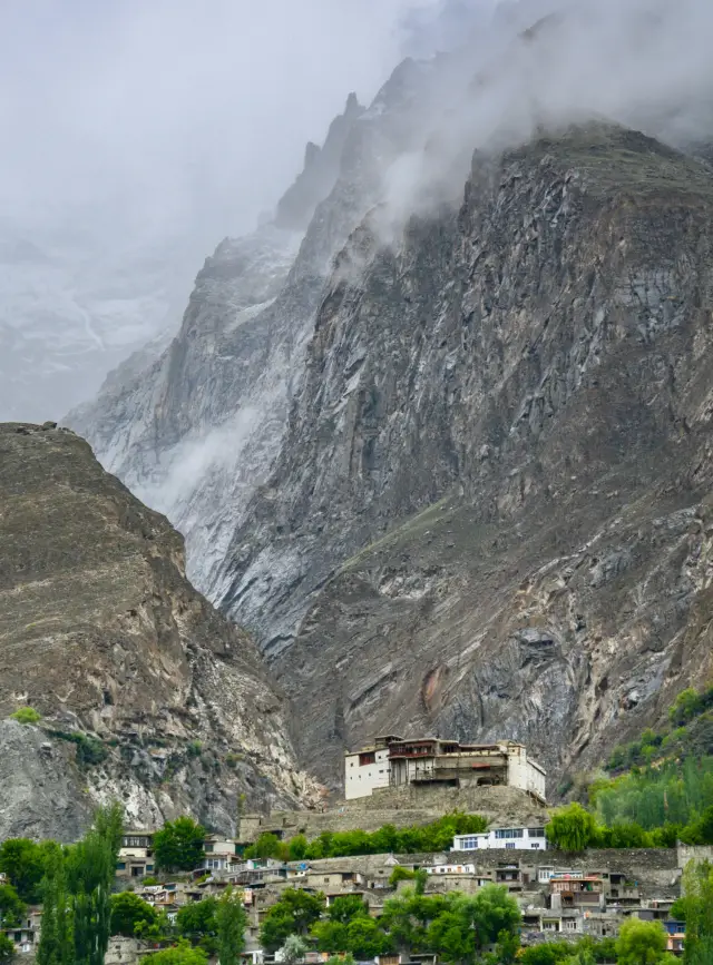 Baltit Fort above the buildings of Karimabad beneath steep mountains.